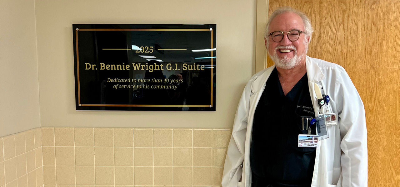 Dr. Bennie Wright stands next to sign dedicating the GI Suite at Bolivar Medical Center to his 40 years of service