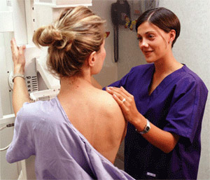 Doctor assisting female patient during mammography